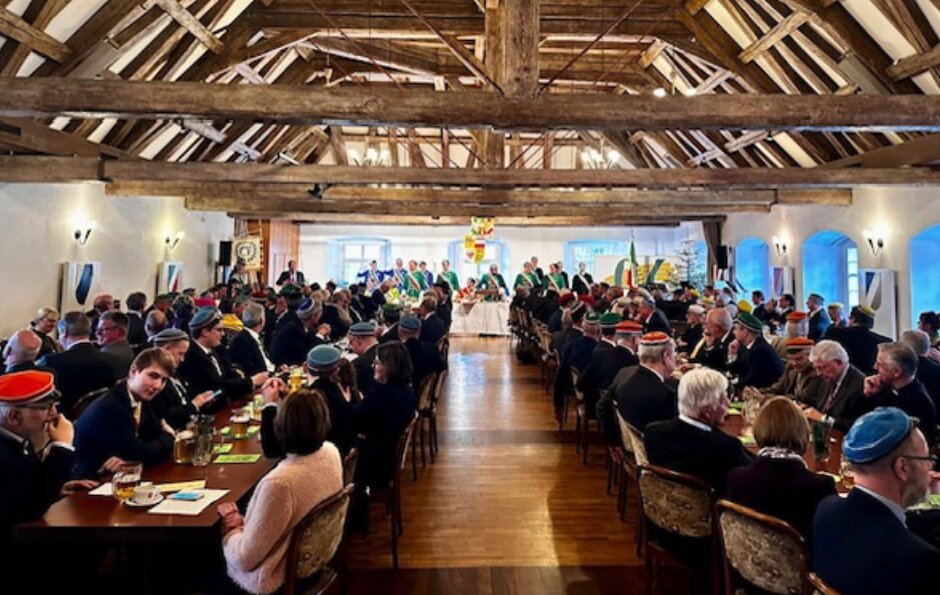 Festkommers mit Couleurstudenten im Hofgarten Aulendorf — Kommerssaal mit Tafeln, Präsidium und Burschenbändern.